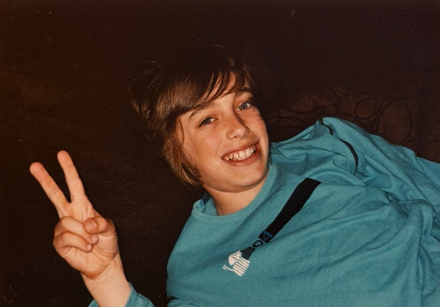 Young Lucas grinning with a peace sign, a film print