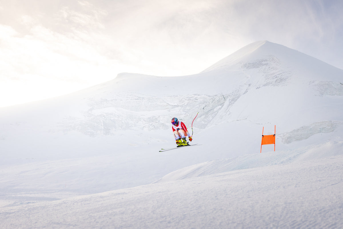 Livio Hiltbrand in a tuck position on the Saas-Fee glacier at sunrise