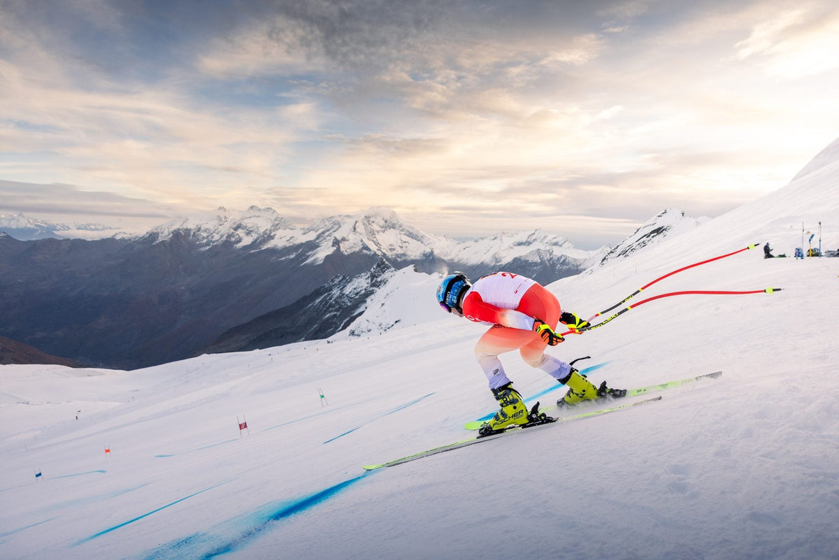 Livio Hiltbrand in a tuck position on the Saas-Fee glacier at sunrise
