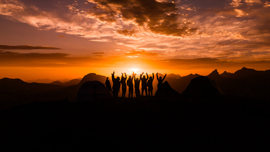 Community cheering at sunrise in front of tents above the Arlberg