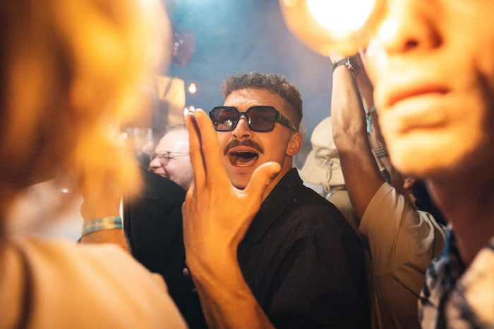 Festival visitor singing in the crowd under warm lights