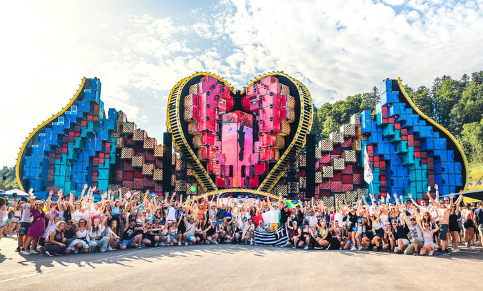 Large group posing in front of a heart shaped festival main stage