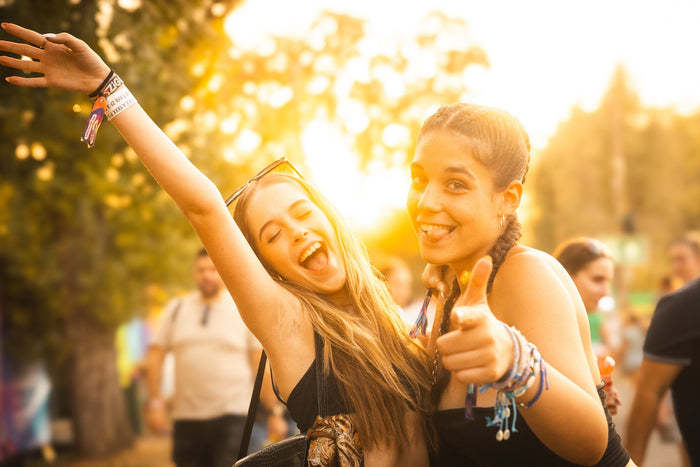 Two friends fooling around in the evening sun at a festival