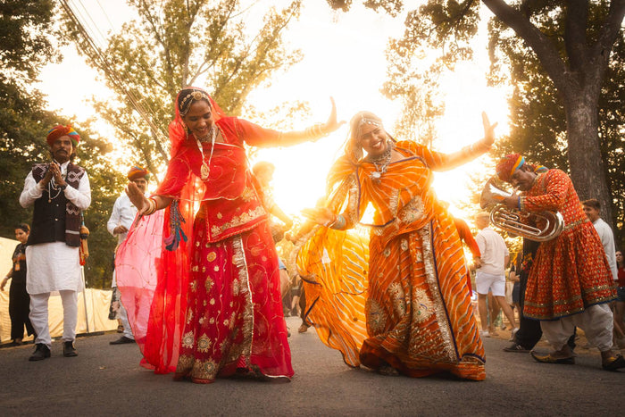 Dancers in traditional Indian dresses performing in the evening sun