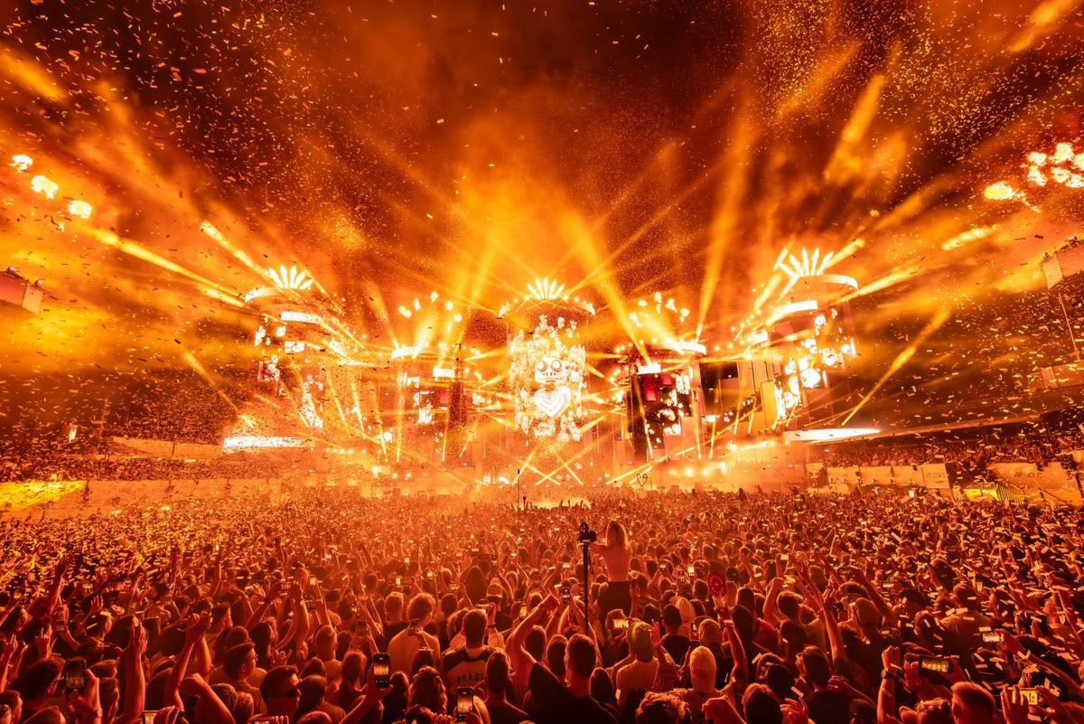 Main stage in orange light with confetti and lasers over the crowd