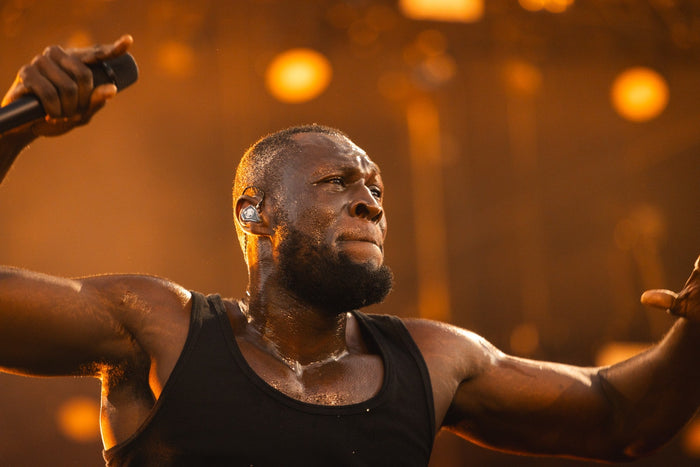 Singer with open arms in warm orange stage light