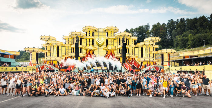 Large group photo in front of a yellow festival main stage