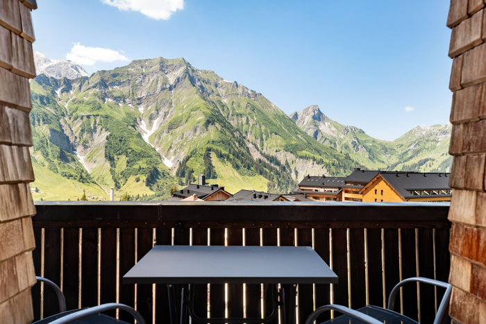 Balcony table with a view of green summer mountains
