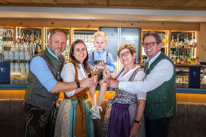 Host family toasting with sparkling wine at the hotel bar