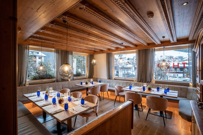 Restaurant with carved wooden ceiling and a winter village view