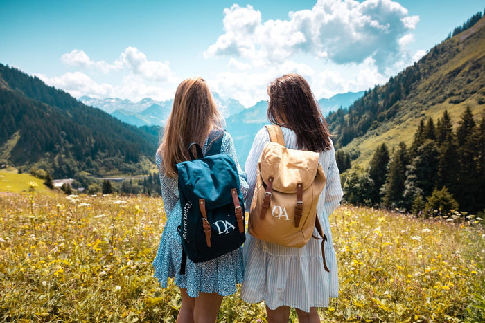 Two guests with DreamAlive backpacks looking into a mountain valley