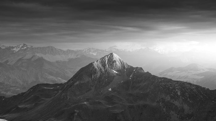 Black and white mountain peak under a dark cloud ceiling