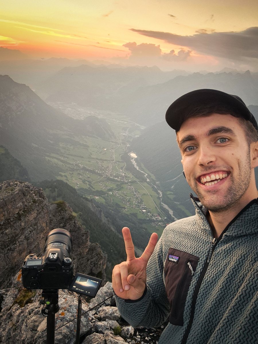 Lucas with his camera on a summit at sunset