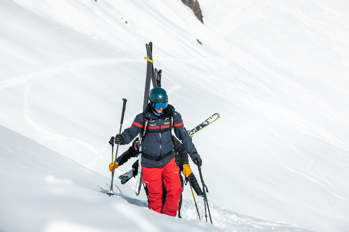 Ski tourers carrying their skis up a steep ridge