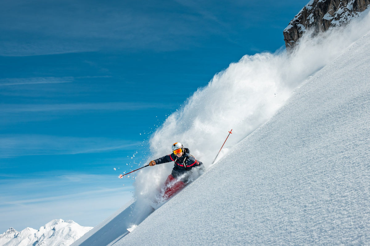 Skier throwing up a wall of snow in deep powder