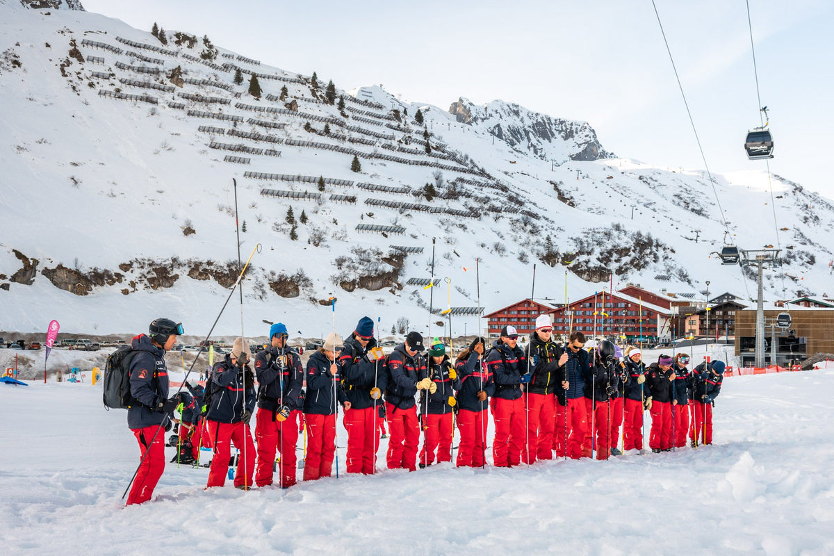 The instructor team of Skischule Zürs lined up in red
