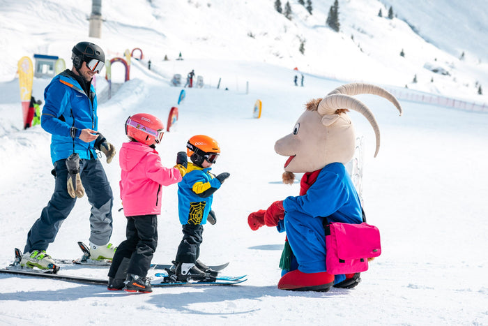 Ski instructor and children meeting the mascot in the Zürs Kinderland