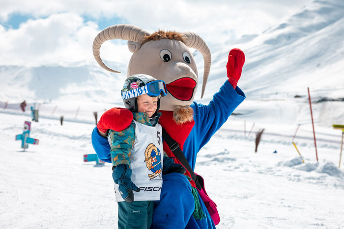 The Skischule Zürs mascot greeting a child in the Kinderland
