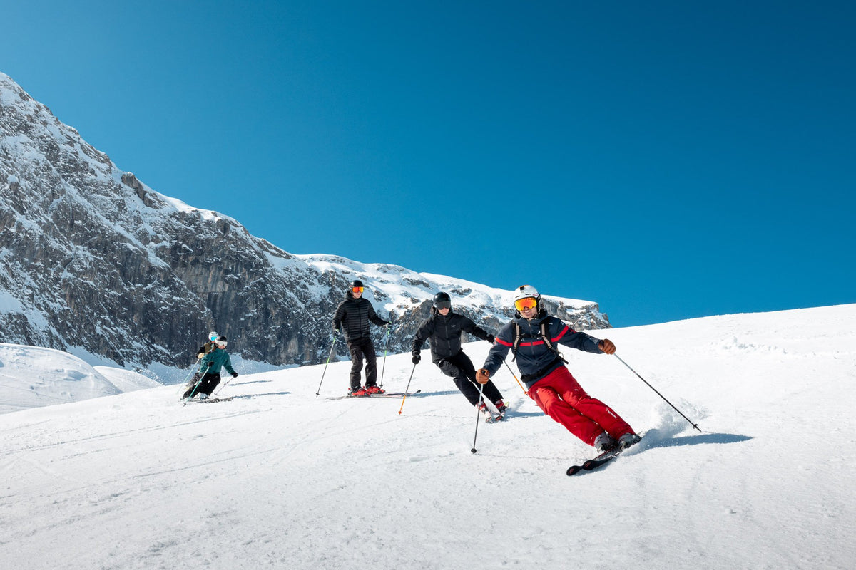 Instructor leading a group down a groomed piste