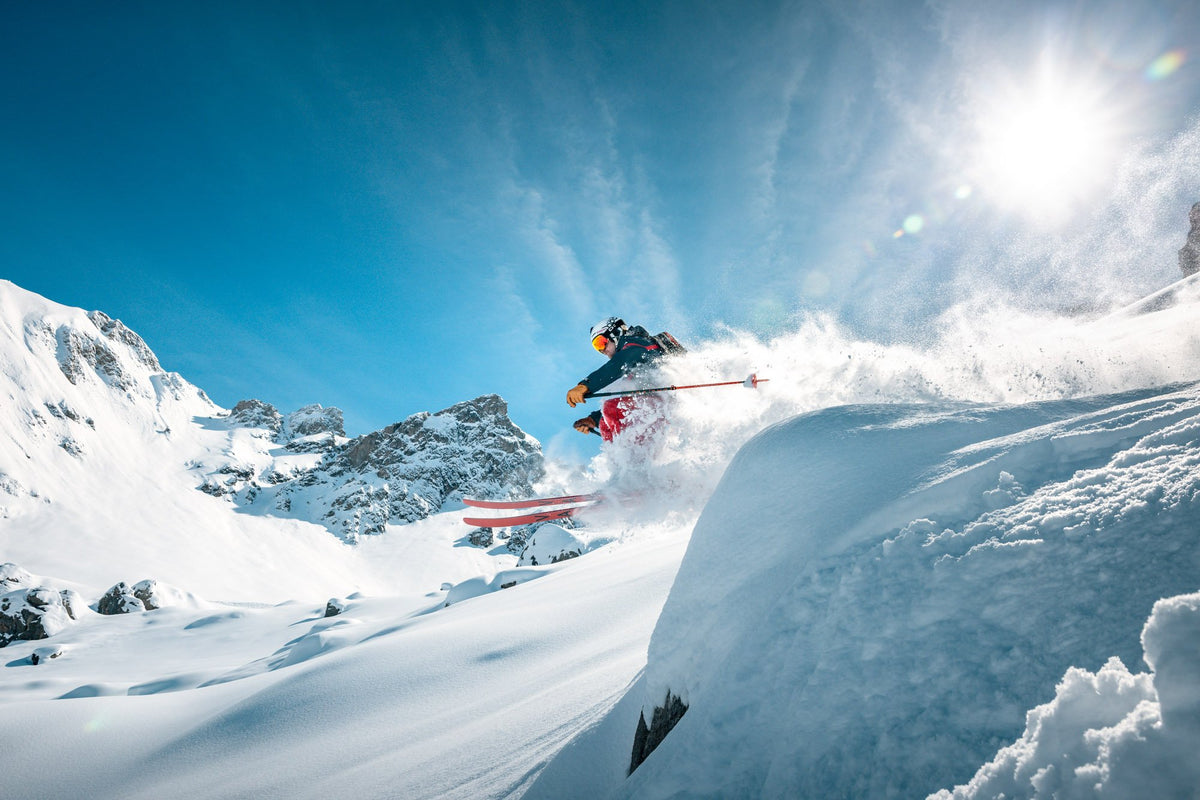 Skier turning in deep powder below the sun, Zürs am Arlberg