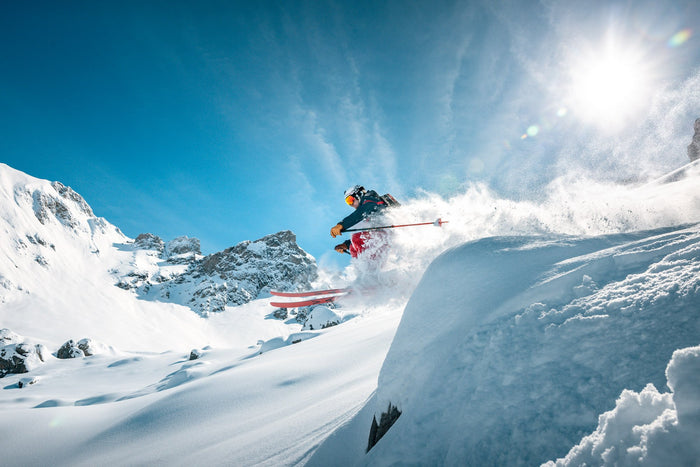 Skier turning in deep powder below the sun, Zürs am Arlberg
