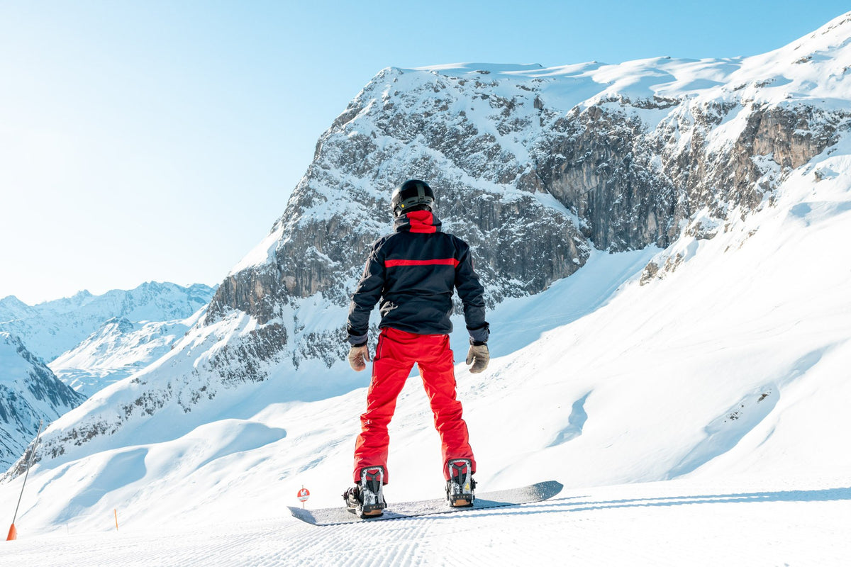 Snowboard instructor on the piste below the rock face